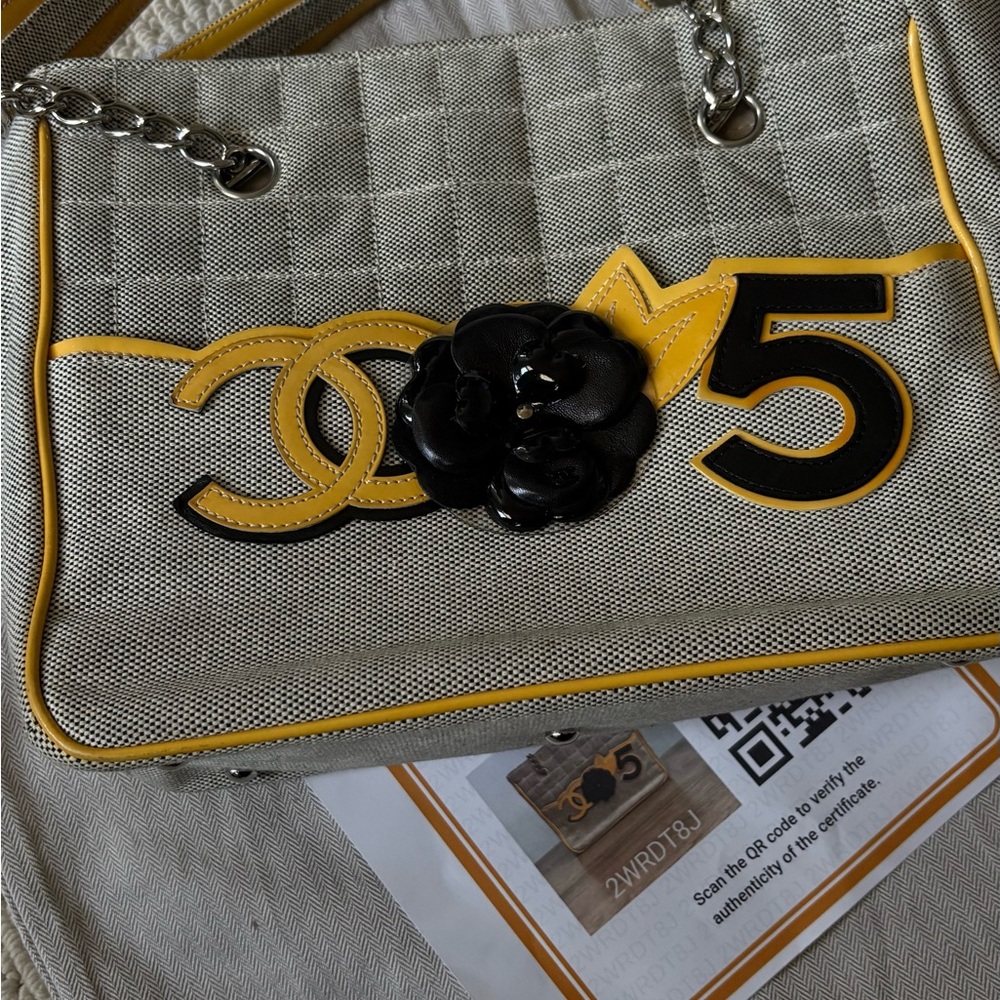 CHANEL Beige Canvas Shoulder Bag with Yellow Trim and Black Camellia
